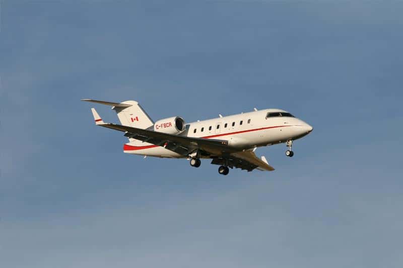 image of a small red and white jet against a blue sky background