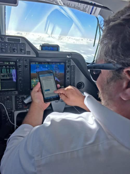 man in cockpit of airplane using a touch screen device