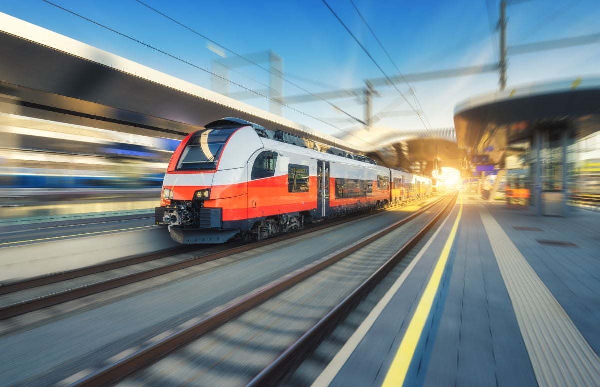 Orange and white railcar leaving station